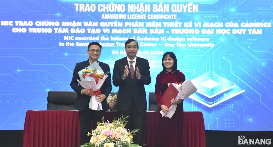 Chủ tịch UBND thành phố Lê Trung Chinh (giữa) trao hóc chúc mừng Trung tâm đào tạo vi mạch bán dẫn của Trường Đại học Duy Tân được nhận giấy chứng nhận bản quyền phần mềm thiết kế vi mạch của Cadence.